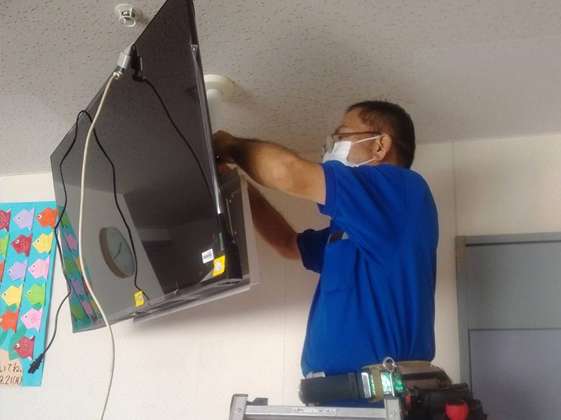 洗濯機の修理点検をするスタッフ